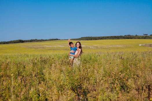 Mother and young son walking in a rural field in summer