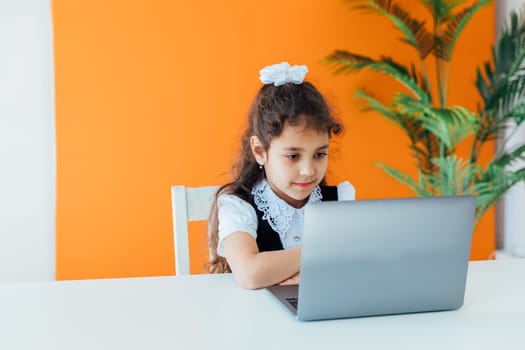 Schoolgirl Doing Homework At Table With Laptop Online