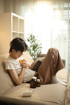 Man dealing with emotional pain and depression at home surrounded by medication.