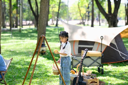 Little girl helping at a family campsite and enjoying a peaceful nature.