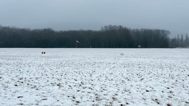A serene winter scene showcases snowcovered fields under a gray sky, ideal for capturing seasonal themes