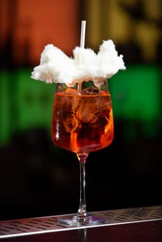 The background features a blurred mix of deep blue and purple hues, suggesting a modern bar or lounge atmosphere