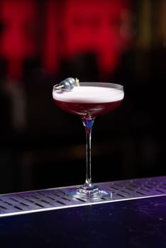 The blurred background features dark tones with hints of green and white bokeh lights, suggesting a stylish bar setting