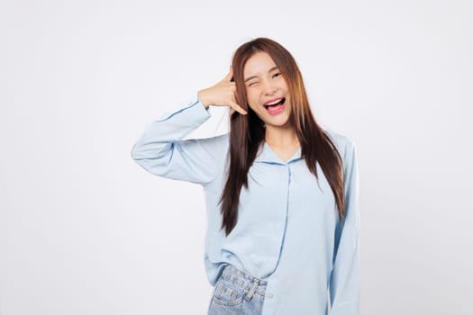 Call me gesture from cheerful woman, second woman winking uses hand as phone with fingers by face, both showing fun and flirty expressions isolated in white studio background setting.