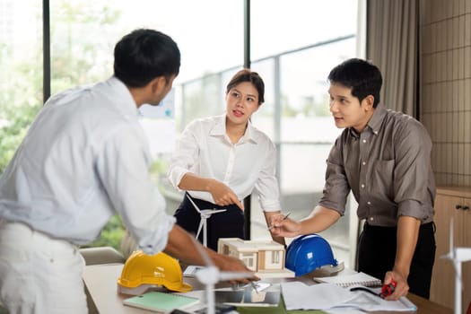 An engineering team discusses innovative concepts for green building models, engaging in a productive brainstorming session.