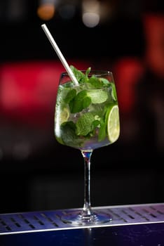 The blurred background features a mix of red, blue, and purple lights, suggesting a vibrant bar atmosphere