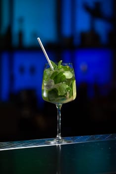 The blurred background features a mix of red, blue, and purple lights, suggesting a vibrant bar atmosphere