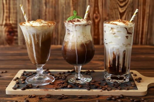 Three delicious coffee beverages are displayed on wooden board, showcasing rich colors and creamy textures. Each drink features unique toppings and presentation.