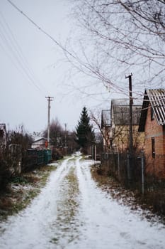 Snowy Path Leading to Rustic Cabins in a Quiet Rural Landscape During Winter