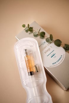 Serum Vial and Natural Skincare Packaging with Herbal Elements on Neutral Background