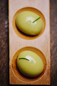 Gourmet Green Spherical Appetizer Dressed With Chives Served On A Wooden Platter