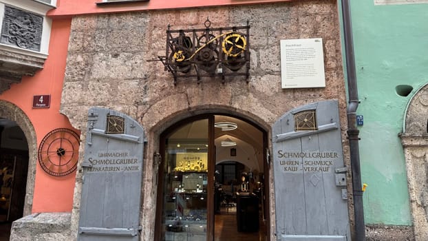 Innsbruck, Austria - March 28, 2025: Historic entrance of Schmiedgasse watchmaker, jewelry shop in Innsbruck displays intricate clockwork design and fine craftsmanship and showcasing vintage decorations, located in a vibrant European street.