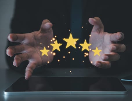 Happy customers are the backbone of any successful business. Show your satisfaction concept with a hand holding five shining stars. Customer service and Satisfaction concept