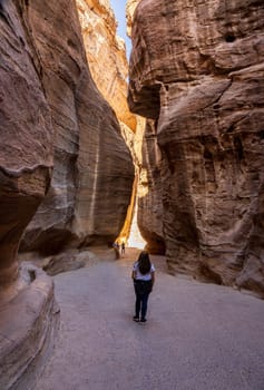 Tourist entering the narrow gorge of the Siq entering Petra in Jordan