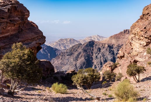 View from the top of the trail to the Monastery of rocky mountain range and gorges with Wadi Araba desert in distance