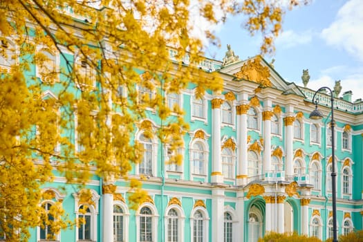 the incredibly picturesque facade of the Winter Palace through the branches of trees on a clear spring day, the heritage of Russia, the most famous landmark of St. Petersburg, the museum. High quality photo