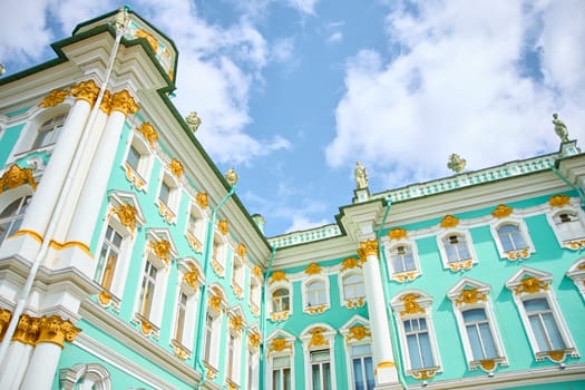 the incredibly picturesque facade of the Winter Palace through the branches of trees on a clear spring day, the heritage of Russia, the most famous landmark of St. Petersburg, the museum. High quality photo