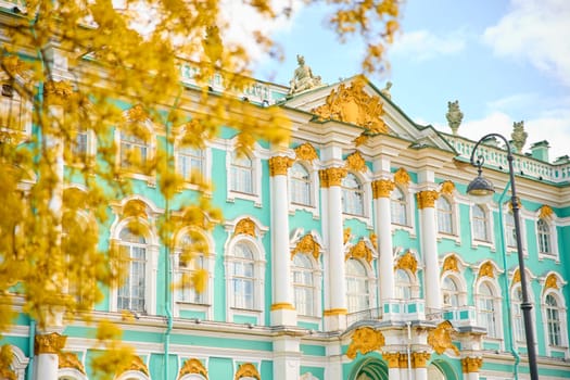 the incredibly picturesque facade of the Winter Palace through the branches of trees on a clear spring day, the heritage of Russia, the most famous landmark of St. Petersburg, the museum. High quality photo