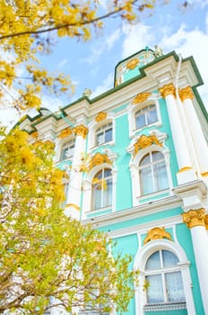 the incredibly picturesque facade of the Winter Palace through the branches of trees on a clear spring day, the heritage of Russia, the most famous landmark of St. Petersburg, the museum. High quality photo