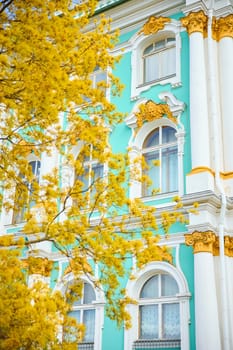 the incredibly picturesque facade of the Winter Palace through the branches of trees on a clear spring day, the heritage of Russia, the most famous landmark of St. Petersburg, the museum. High quality photo