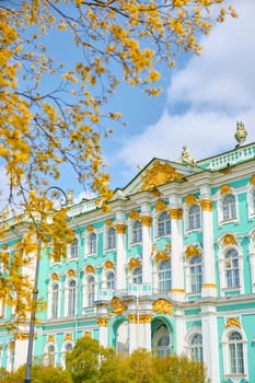 the incredibly picturesque facade of the Winter Palace through the branches of trees on a clear spring day, the heritage of Russia, the most famous landmark of St. Petersburg, the museum. High quality photo