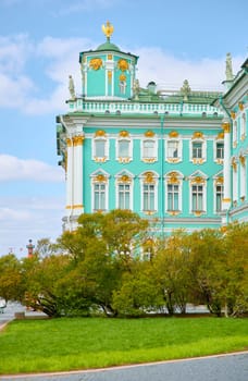 the incredibly picturesque facade of the Winter Palace through the branches of trees on a clear spring day, the heritage of Russia, the most famous landmark of St. Petersburg, the museum. High quality photo