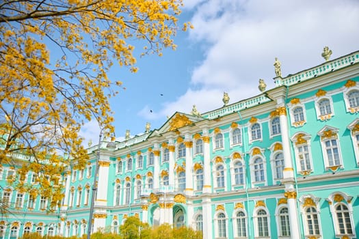 the incredibly picturesque facade of the Winter Palace through the branches of trees on a clear spring day, the heritage of Russia, the most famous landmark of St. Petersburg, the museum. High quality photo