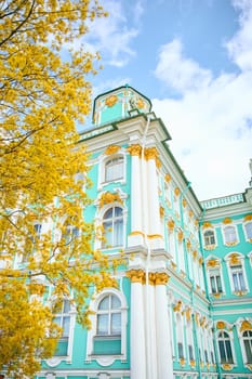 the incredibly picturesque facade of the Winter Palace through the branches of trees on a clear spring day, the heritage of Russia, the most famous landmark of St. Petersburg, the museum. High quality photo