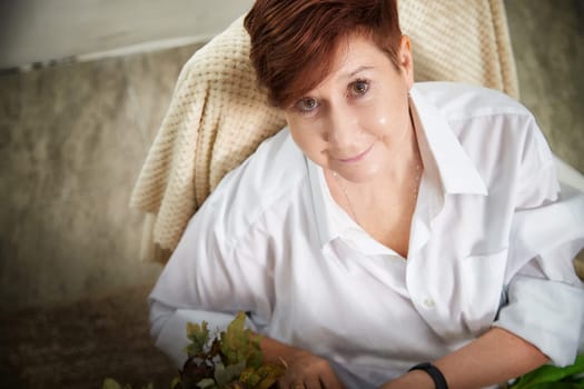 The woman sits comfortably in her cozy room, capturing a moment while engaged in her lifestyle blog.