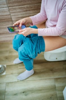 Enjoying a relaxing moment in the bathroom while browsing a smartphone.