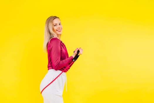 Sports woman in fashion sportswear exercising with elastic band in a studio