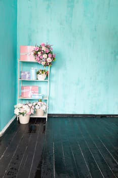 Gift shelves with a vase of flowers in the interior of a blue room