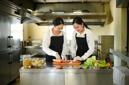 Culinary instructor guiding a student through carrot slicing during a practical cooking class.