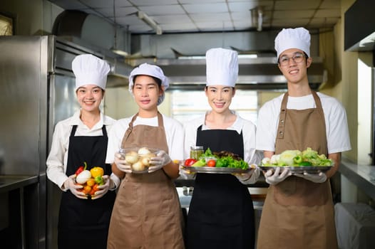 Group of culinary students proudly holding fresh vegetables, ready for their cooking class.