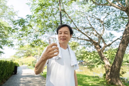 A joyful man smiles while holding a water bottle on his morning walk, representing wellness and a positive lifestyle.