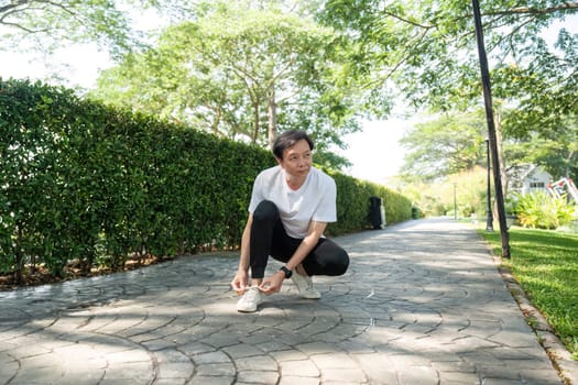 An elderly man checks his smartwatch in a park, emphasizing wellness and fitness tracking.