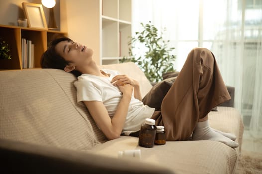 Sad man in casual clothes slumped on sofa expressing emotional burnout and despair at home..