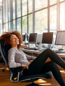 AI-generated vertical image of a smiling woman leaning back in a chair at a modern office with computers. Bright workspace with sunlight, casual posture, and positive atmosphere.