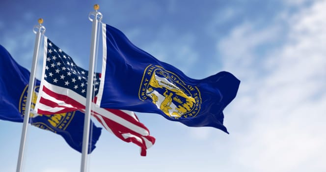 Nebraska state flag waving with the American flag on a clear day. Dark blue with a large state seal of Nebraska at its center. 3d illustration render. Rippling fabric. US state flag