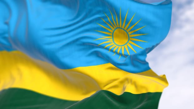Close-up of Rwanda national flag waving on a clear day. Three horizontal bands: blue, yellow, green with 24 rays yellow sun. 3d illustration render. Selective focus