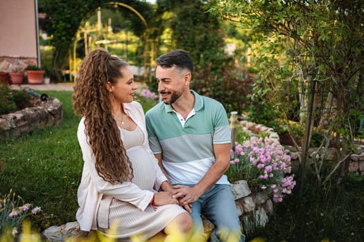 Expecting parents enjoy relaxation and love in peaceful garden.