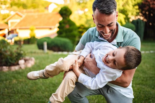 Father and son share a joyful outdoor moment.
