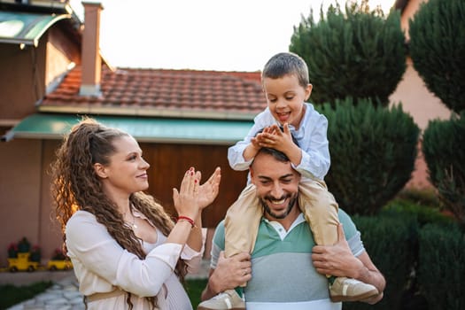 A cheerful family enjoys playful moments in a sunny garden.