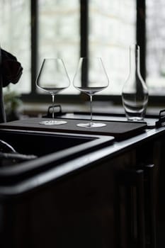 Clean wine glasses and decanter are on the table of a special wine cabinet, stylish table setting, ice, light from window, decoder and degasser. High quality photo