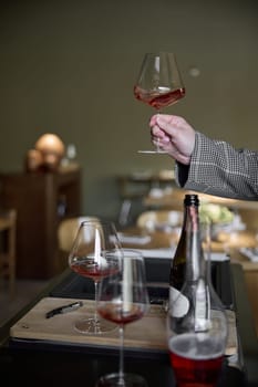 Champagne tasting in restaurant, A man holds in his hand a beautiful elegant glass with rose sparkling wine. High quality photo