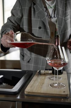 Champagne tasting, The sommelier pours sparkling wine from the decanter into a beautiful glass, Wine glasses are on the table, stylish table setting, sparkling wine bubbles. High quality photo