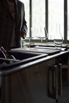 Clean wine glasses and decanter are on the table of a special wine cabinet, stylish table setting, ice, light from window, decoder and degasser. High quality photo
