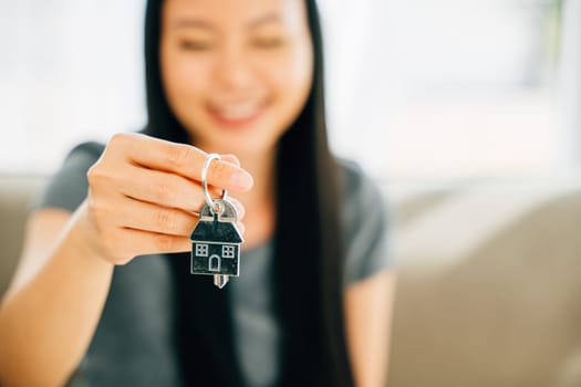 A female hand displays a house key exuding success and security in real estate. Symbolizing achievement confidence and the joy of homeownership.