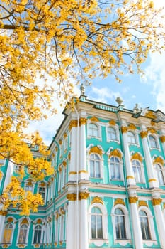 the incredibly picturesque facade of the Winter Palace through the branches of trees on a clear spring day, the heritage of Russia, the most famous landmark of St. Petersburg, the museum. High quality photo