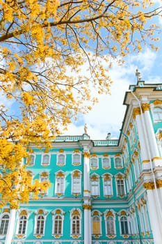 the incredibly picturesque facade of the Winter Palace through the branches of trees on a clear spring day, the heritage of Russia, the most famous landmark of St. Petersburg, the museum. High quality photo